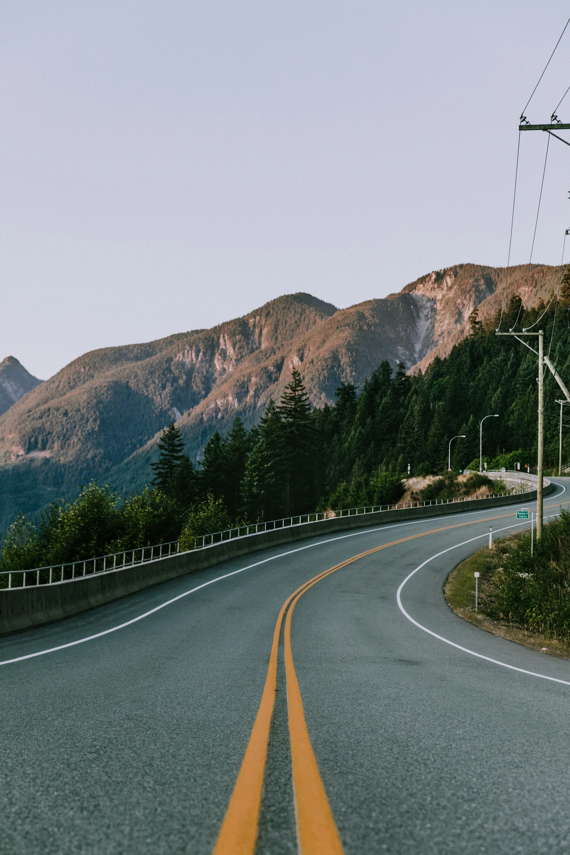 A mountain road through a forest, photographed by Nathan Dumlao. An illustrative setting, separate from the San Francisco map.